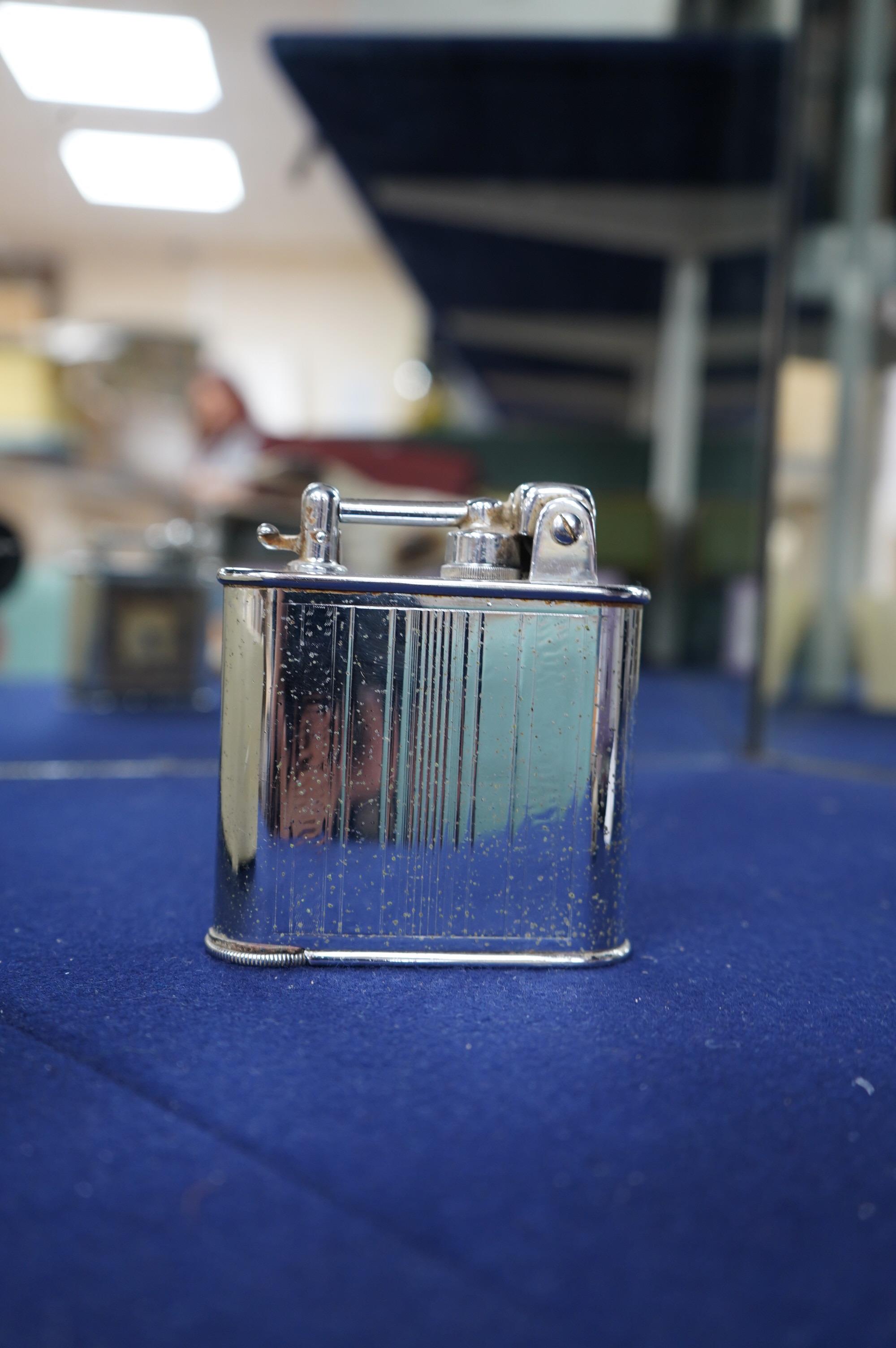 A Lancel Automatique table lighter incorporating an eight day timepiece, 9.5cm high. Condition - fair, some discolouration to the dial.